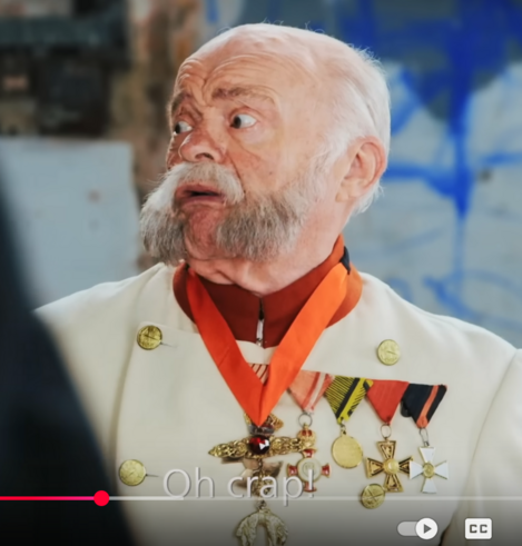 Image of an actor playing the Kaiser Franz Joseph of Austria Hungary in a The cause of World War One! Origins: Rap Battle | WW1 Uncut - BBC.

Person looks very terrified, because it was intimidated by the appearance of a Tzar the Nicholas a few seconds ago. Subtitles says Oh Crap!